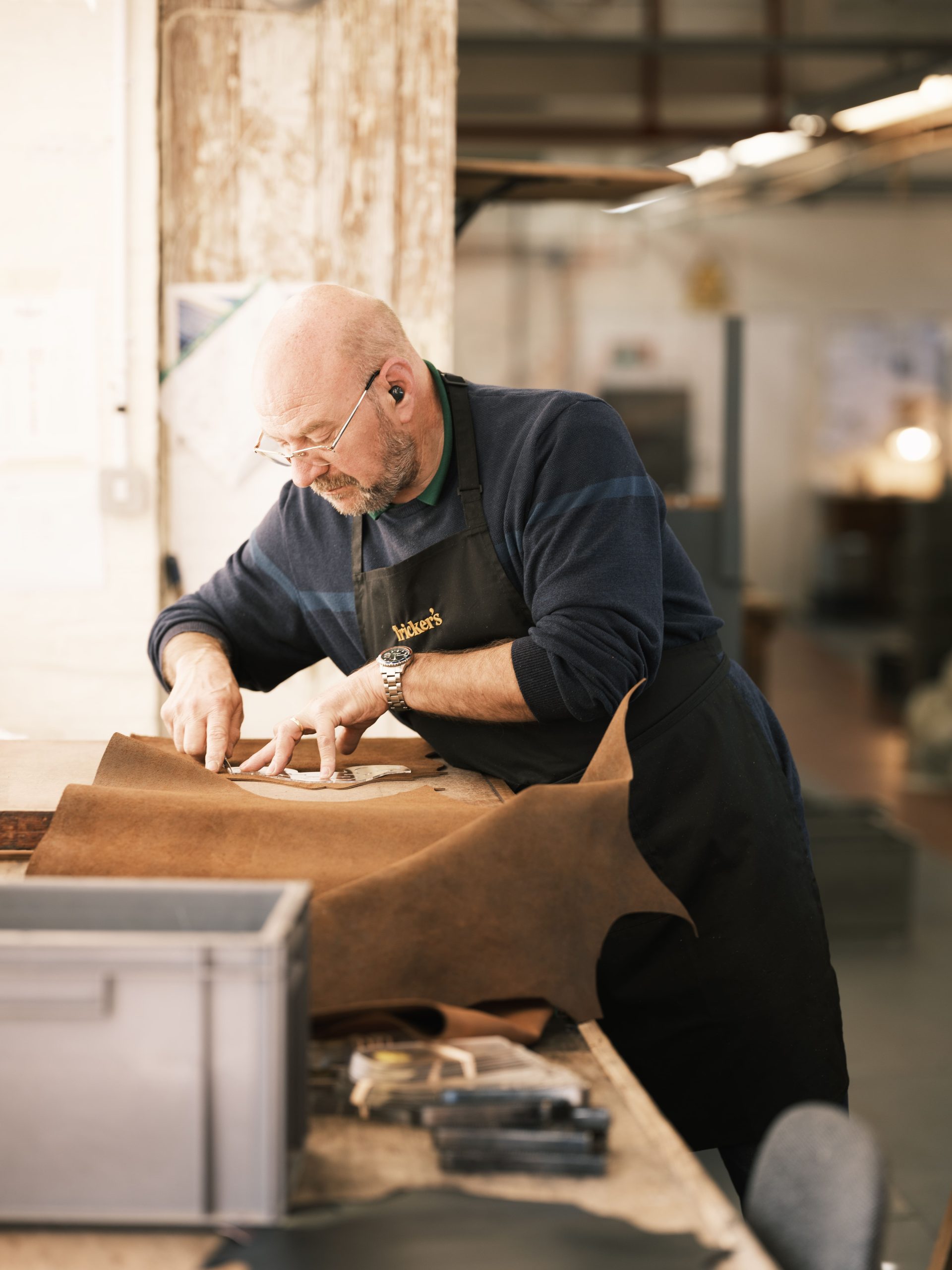 A Tricker's craftsman cutting leather by hand at the Northampton factory