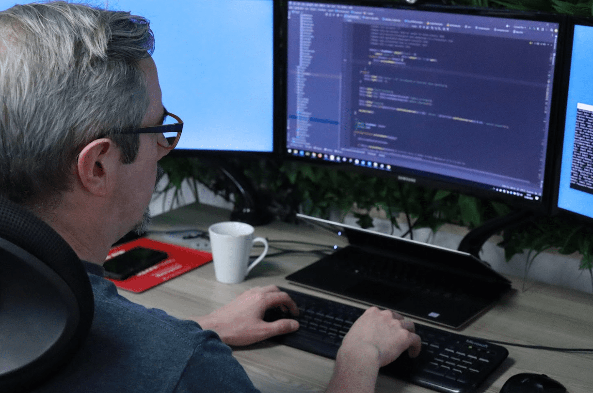 A developer working on site code across two monitors