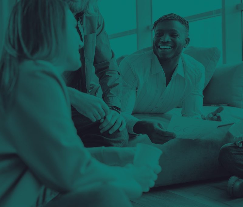 Colleagues talking and laughing around a coffee table